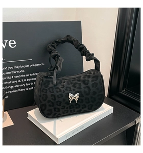 Detail of black leopard print underarm bag with silver butterfly and ruched handle