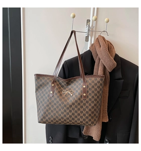 Vue détaillée du sac cabas monogramme marron foncé avec fermoir nœud doré et bandoulière
