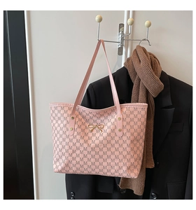 Détail du sac cabas rose avec imprimé monogramme M et élégant nœud doré décoratif