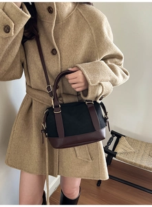 Retro Boston bag in black canvas and brown leather on model in beige coat