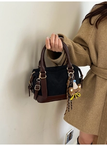 Detail of vintage crossbody bag in canvas and PU leather with a cute bear charm accessory