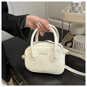 Close-up of cream white leather pillow bag with gold FASHION & BAGS logo and metal zipper