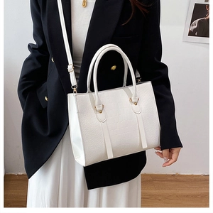 Detail of white crocodile pattern tote with gold hardware and removable shoulder strap