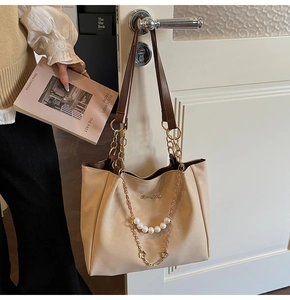 Vue détaillée du sac cabas beige avec chaîne dorée, sangle en perles et texture PU