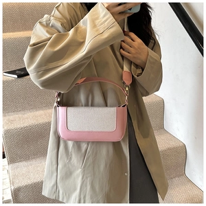 Dettaglio borsa a tracolla rosa e beige con tracolla larga rimovibile e gancio in metallo
