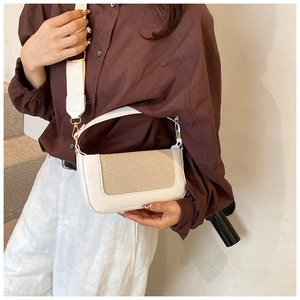 Dettaglio borsa sottobraccio in pelle bianca con patchwork in tessuto beige e parti in oro
