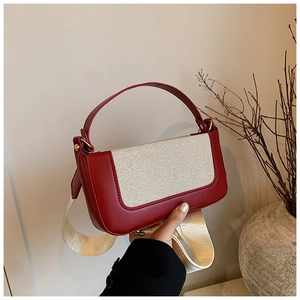 Dettaglio borsa a spalla patchwork in pelle rossa e tela beige con fibbia dorata
