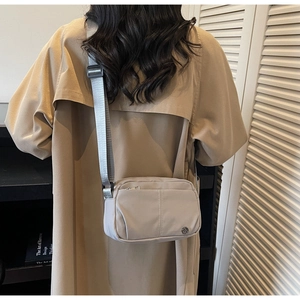 Detail of water-resistant nylon crossbody bag with adjustable strap and metal logo