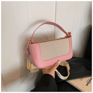 Dettaglio della borsa a tracolla in pelle rosa e tessuto beige con fibbie dorate