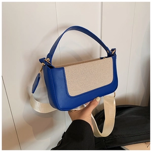 Dettaglio della borsa a spalla in pelle blu navy e tela beige con hardware dorato