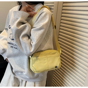 Close-up of yellow waterproof nylon square crossbody bag with dual-layer zippers