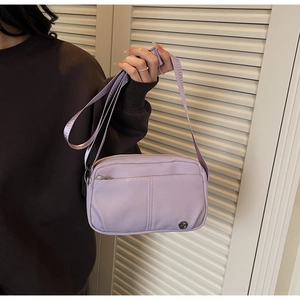 Detail of lavender purple crossbody bag with adjustable strap and front zipper pocket