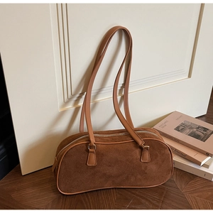 Detail of vintage brown suede shoulder bag with metallic zipper and smooth leather strap