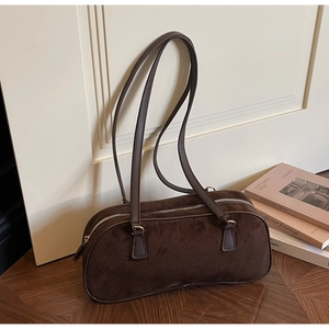 Close-up of vintage brown faux suede shoulder bag with fine texture and leather straps