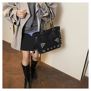 Detailed view of the black tote bag featuring a cute cat face embroidery and drawstring side