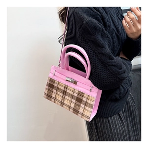 Dettaglio della borsa in pelle rosa con motivo a quadri e chiusura in argento sulla spalla