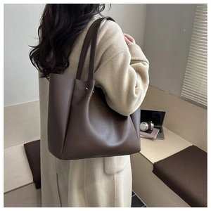 Macro detail of dark brown PU leather tote bag with sturdy straps and metal rivets
