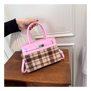 Dettaglio della borsa in pelle rosa e tessuto scozzese con chiusura a scatto in metallo