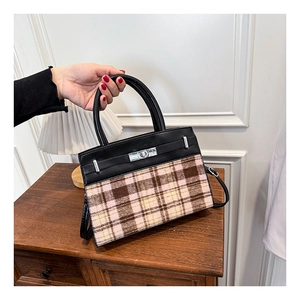 Dettaglio elegante borsa bicolore con motivo a quadri vintage e chiusura a scatto argento