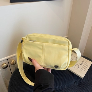 Modern bright yellow nylon crossbody bag with adjustable strap and front zipper pocket