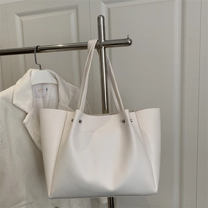 Minimalist white leather tote bag with silver studs and long shoulder straps
