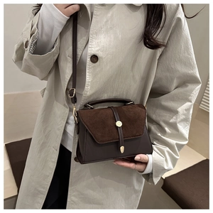 Détails du sac bandoulière en daim marron foncé avec boucle ronde en métal doré poli