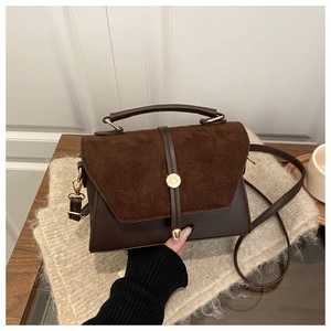 Vue détaillée du sac bandoulière en daim et cuir marron avec une boucle dorée élégante