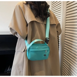 Détail du sac bandoulière vert menthe avec texture nylon et large bandoulière réglable