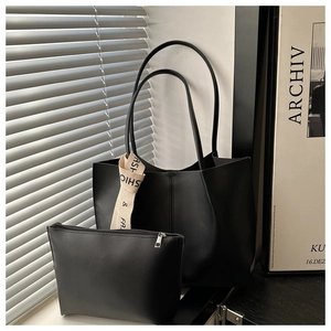 Dettaglio della borsa tote nera minimalista con nastro moda e pochette abbinata