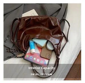 Detailed view of large capacity interior for tablet and essentials in dark brown tote bag