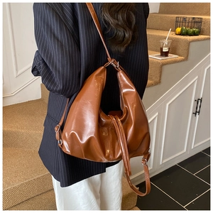 Rear view of brown PU leather hobo bag with pleated bottom and slim shoulder strap