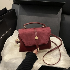 Sac bandoulière bordeaux en daim et cuir avec boucle métallique dorée et poignée supérieure