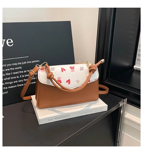 Detail of bear print crossbody bag with brown knot handle and red heart patterns