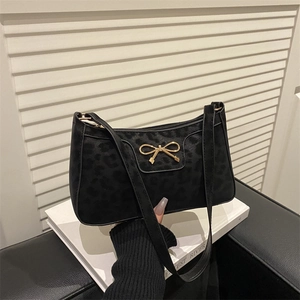 Black bow shoulder bag with subtle leopard pattern and gold hardware on white background