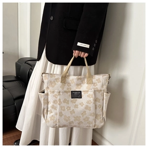Detail of floral canvas tote bag showing cream fabric and deep brown flower pattern
