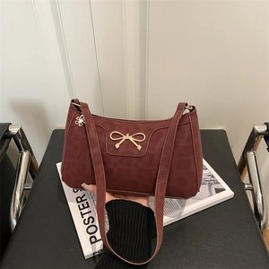 Chic burgundy hobo bag with subtle leopard texture and gold metal bow detail