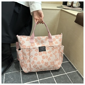 Detail of pink floral tote bag showing textured canvas fabric and FASHION INSTINCT woven label