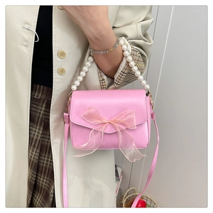 Pink lady crossbody bag featuring a sheer mesh bow and an elegant pearl bead handle