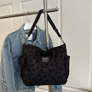 Black floral canvas tote bag with dual handles and detachable shoulder strap for daily use