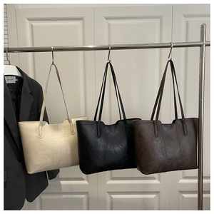 Detailed display of tote bags in white, black, and brown with retro leather texture