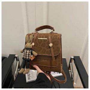Detail of leopard print suede and smooth leather bag with a cute plush rabbit charm