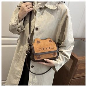 Detail of cute cat-shaped toast handbag showing the suede texture and adjustable strap
