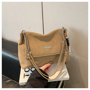 Close-up of khaki retro textured shoulder bag with chain strap and bead charms
