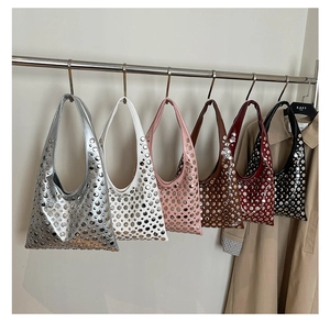 Row of studded hobo shoulder bags in six colors hanging on a metal rack