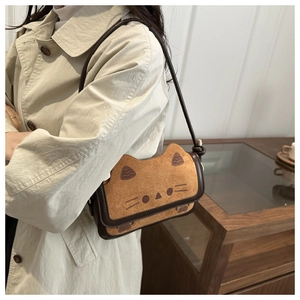Detail of cute cat shaped crossbody bag showing orange suede texture and leather trim
