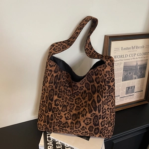 Large leopard print canvas tote bag for women placed on books in a stylish setting