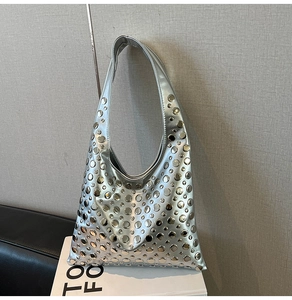 Detail of silver metallic tote bag featuring various sized circular rivet decorations