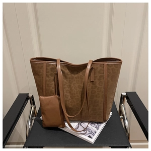 Détail du sac cabas imprimé léopard avec pochette sur une chaise en métal noir