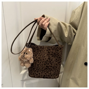 Detail van luipaardprint emmertas met pluche textuur en schattige puppy hanger