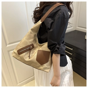 Detail of vintage canvas tote with brown leather pocket and adjustable shoulder strap